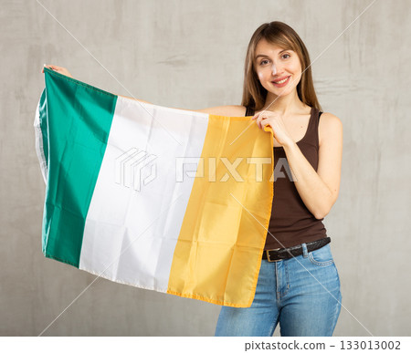 Pretty girl holding the Ireland flag in her hands Pretty girl holding the Ireland flag in her hands 133013002