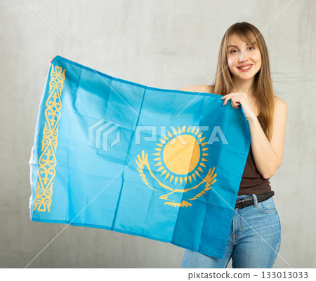 Joyful female fan of favorite team of Kazakhstan with the national flag in her hands Joyful female fan of favorite team of Kazakhstan with the national flag in her hands 133013033