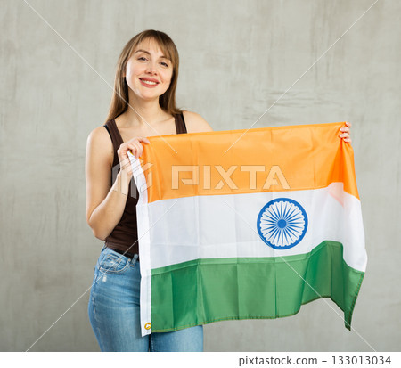 Young cheerful woman holding India flag Young cheerful woman holding India flag 133013034