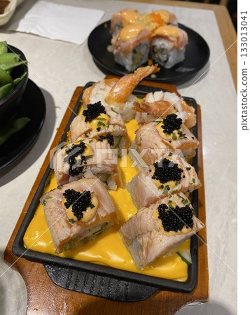An assortment of fresh sushi, artfully arranged with a variety of toppings and vibrant colors. This traditional Japanese dish combines vinegared rice, seafood, and vegetables for an experience. 133013041