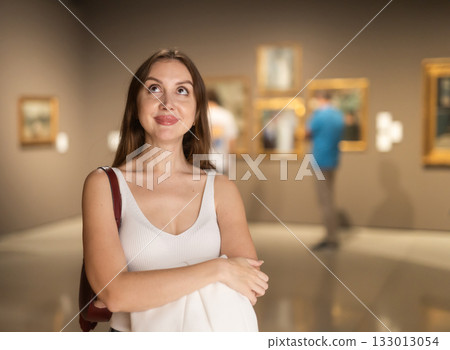 Girl view pictures and icons in museum hall 133013054