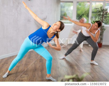 Happy women practicing aerobics in light fitness studio 133013072