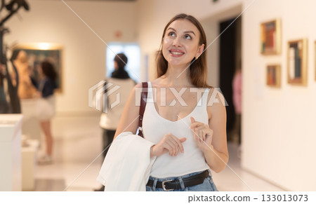 Girl view pictures and icons in museum hall 133013073