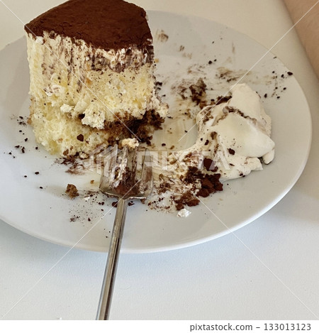 Soft and creamy tiramisu slice layered with rich mascarpone, espresso-soaked ladyfingers, and a dusting of cocoa powder, offering a perfect balance of sweetness and bold coffee flavor in every bite. 133013123