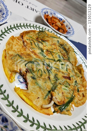 Crispy and savory Korean Pajeon, or scallion pancake, made with green onions and a variety of vegetables. A delicious, traditional Korean snack perfect for any meal. 133013129