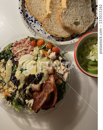 Fresh vegetable salad with a vibrant mix of greens, cherry tomatoes, cucumbers, and bell peppers. Crisp, colorful, and packed with vitamins, this salad makes a healthy, delicious meal or side. 133013162