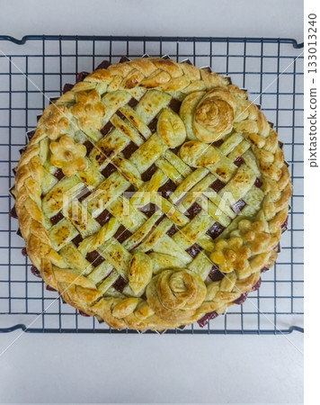 Warm and comforting apple pie with a golden, flaky crust and sweet cinnamon-spiced apple filling, offering a perfect bite of classic homemade flavor and cozy indulgence in every slice. 133013240