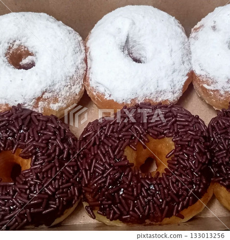 Delicious doughnuts with a golden, fluffy texture, topped with colorful glazes and sprinkles. Perfect for dessert or breakfast photography, showcasing the sweet indulgence of these classic treats. Delicious doughnuts with a golden, fluffy texture, topped with colorful glazes and sprinkles. Perfect for dessert or breakfast photography, showcasing the sweet indulgence of these classic treats. 133013256