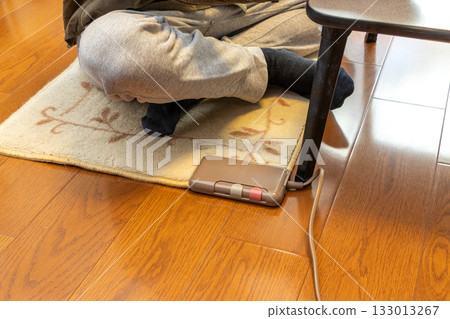 A man relaxing cross-legged on an electric carpet A man relaxing cross-legged on an electric carpet 133013267