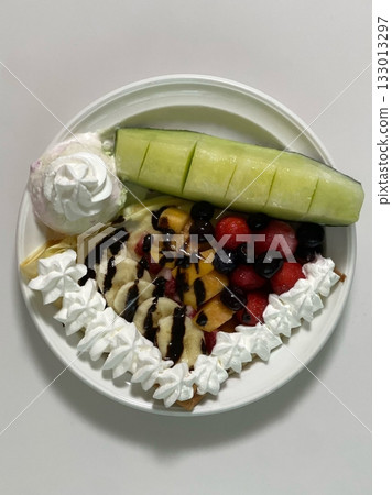Delicious ice cream-filled crepes, drizzled with chocolate sauce and topped with fresh fruits. Perfect for dessert photography, showcasing the delightful combination of flavors and texture Delicious ice cream-filled crepes, drizzled with chocolate sauce and topped with fresh fruits. Perfect for dessert photography, showcasing the delightful combination of flavors and texture 133013297