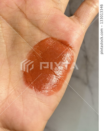 Lipstick swatches on the hand showcasing a range of vibrant shades and finishes, offering a perfect view of color payoff, texture, and undertones in every bold and beautiful swipe. 133013346
