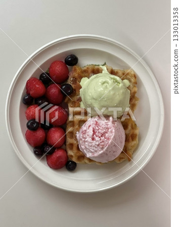 Crispy, golden waffles topped with creamy ice cream, creating a perfect balance of warm and cold, crunchy and smooth. A delightful dessert or breakfast treat, with toppings like fruits or syrup. Crispy, golden waffles topped with creamy ice cream, creating a perfect balance of warm and cold, crunchy and smooth. A delightful dessert or breakfast treat, with toppings like fruits or syrup. 133013358