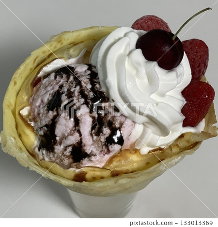 Delicious ice cream-filled crepes, drizzled with chocolate sauce and topped with fresh fruits. Perfect for dessert photography, showcasing the delightful combination of flavors and texture 133013369