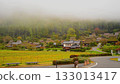 A misty thatched roof village in autumn 133013417