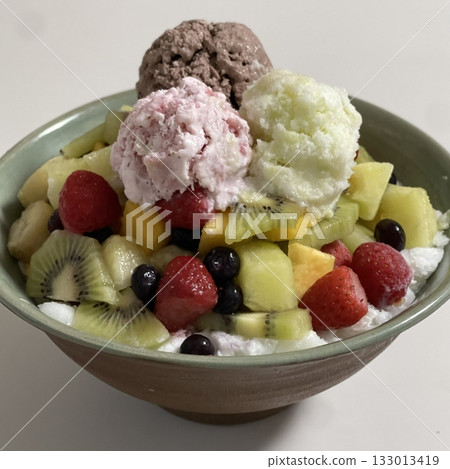 Refreshing bingsu, a Korean shaved ice dessert topped with sweet ingredients like red beans, fruits, and condensed milk. A perfect treat to cool down on hot days. Refreshing bingsu, a Korean shaved ice dessert topped with sweet ingredients like red beans, fruits, and condensed milk. A perfect treat to cool down on hot days. 133013419