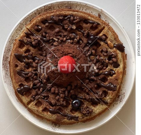 Crispy, golden waffles topped with creamy ice cream, creating a perfect balance of warm and cold, crunchy and smooth. A delightful dessert or breakfast treat, with toppings like fruits or syrup. 133013472