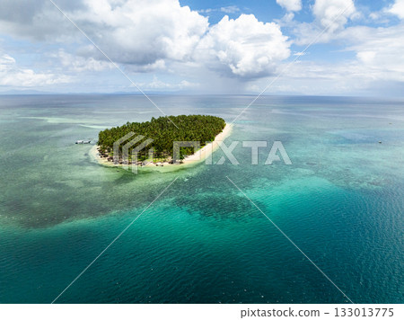 Remote island covered with palm trees surrounded by turquoise clear water and coral reef. Siargao, Philippines. Casa Desideria. 133013775