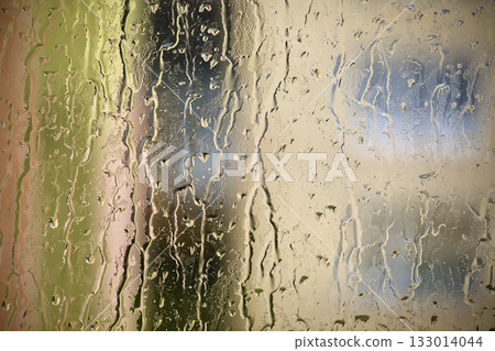 Raindrops on glass creating a beautiful abstract background with natural light 133014044