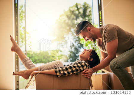 New home, funny and couple pushing box, having fun and bonding in apartment. Real estate, laughing and man and woman in cardboard, play and enjoying quality time together while moving into property. New home, funny and couple pushing box, having fun and bonding in apartment. Real estate, laughing and man and woman in cardboard, play and enjoying quality time together while moving into property. 133014133