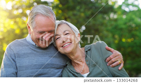 Laughing, love and senior couple in a park together hugging with care, happiness and romance. Smile, nature and elderly man and woman in retirement embracing while sitting in an outdoor green garden. 133014268