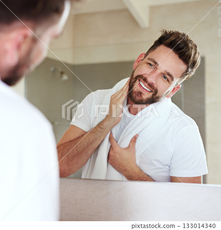 Grooming, face and mirror for man with skincare and self care routine in a bathroom with a smile. Home, reflection and cleaning with a young male person feeling happy from beard growth or dermatology 133014340