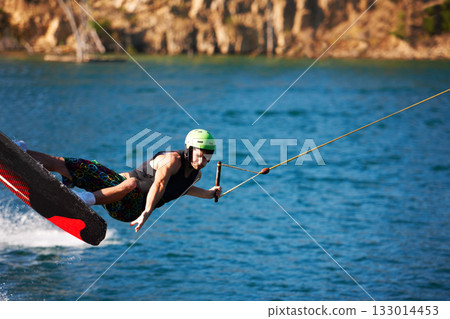 Surfing, wakeboard and extreme sports with man in lake for action, summer break and travel vacation. Wave, adrenaline junkie and fitness with guy skiing on river for health, adventure and speed Surfing, wakeboard and extreme sports with man in lake for action, summer break and travel vacation. Wave, adrenaline junkie and fitness with guy skiing on river for health, adventure and speed 133014453