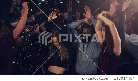 Friends, celebration and dancing in club with glitter, confetti or new years eve party with happiness, crowd and disco. Dance, people and festival with music, energy and cheering for birthday event 133014494