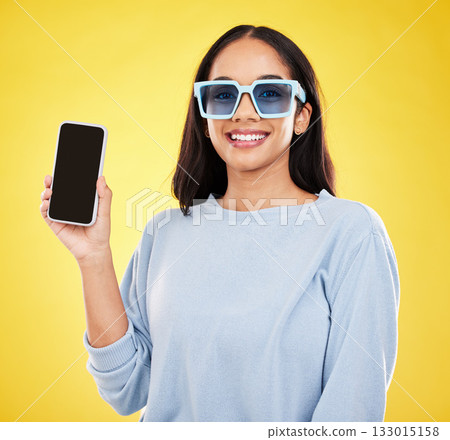 Phone, fashion and portrait of woman with sunglasses in yellow studio for social media, website and internet. Communication, mockup space and happy girl on smartphone for chat, promotion and network Phone, fashion and portrait of woman with sunglasses in yellow studio for social media, website and internet. Communication, mockup space and happy girl on smartphone for chat, promotion and network 133015158