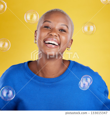 Black woman, studio portrait and soap bubbles for student smile, happiness or beauty by yellow background. Happy girl, model or fashion with excited face, cosmetics or gen z aesthetic with confidence 133015347