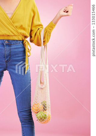 Hand, shopping bag and fruits for woman in studio by pink background for diet, health or deal in recycle material. Grocery discount, fruit or healthy food with produce, sustainability and lifestyle 133015466
