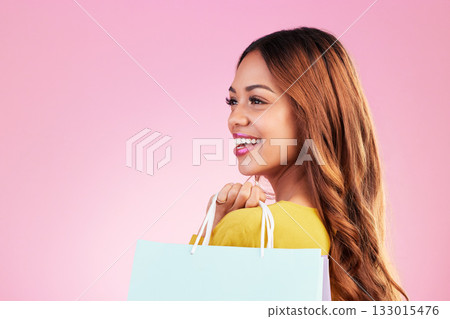 Woman, shopping bag and thinking of space in studio with a customer happy about promotion or discount. Female model or shopper on a pink background for fashion, sale and gift or surprise with a smile 133015476