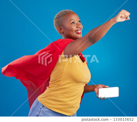 Superhero, mockup and phone with black woman in studio for flying, power and deal. Mobile, strong and communication with female in red cape costume on blue background for technology, digital and 5g Superhero, mockup and phone with black woman in studio for flying, power and deal. Mobile, strong and communication with female in red cape costume on blue background for technology, digital and 5g 133015652
