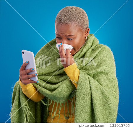 Sick black woman, phone and blowing nose on background, studio and allergies from winter virus. Female model, influenza and smartphone for telehealth app, covid healthcare and search symptoms online Sick black woman, phone and blowing nose on background, studio and allergies from winter virus. Female model, influenza and smartphone for telehealth app, covid healthcare and search symptoms online 133015705