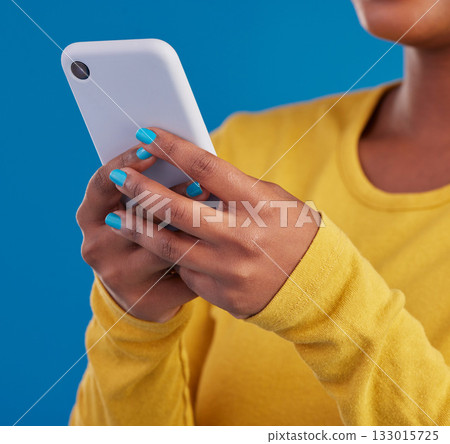 Phone, typing and closeup of hands of woman in studio for social media, text message and browse website. Communication, technology and girl on internet, network and chat online on blue background Phone, typing and closeup of hands of woman in studio for social media, text message and browse website. Communication, technology and girl on internet, network and chat online on blue background 133015725