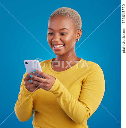 Phone, typing and black woman in studio with smile for social media, text message and browse website. Communication mockup, technology and girl on internet, network and chat online on blue background Phone, typing and black woman in studio with smile for social media, text message and browse website. Communication mockup, technology and girl on internet, network and chat online on blue background 133015730
