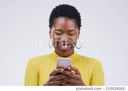 Social media, black woman on smartphone and smile against a white background. Connectivity or technology, communication or texting and African female person happy with cellphone in a studio backdrop Social media, black woman on smartphone and smile against a white background. Connectivity or technology, communication or texting and African female person happy with cellphone in a studio backdrop 133016002