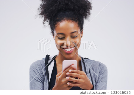 Phone, happy and African woman typing in studio with smile for social media, internet and online chat. Communication, white background and female person on smartphone for website, mobile app and text Phone, happy and African woman typing in studio with smile for social media, internet and online chat. Communication, white background and female person on smartphone for website, mobile app and text 133016025