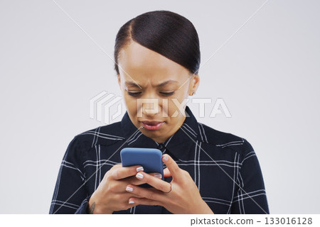 Confused, phone and woman typing in studio isolated on a white background. Problem, cellphone and female person frustrated on app, fake news or browsing online, social media and glitch, spam or scam. 133016128