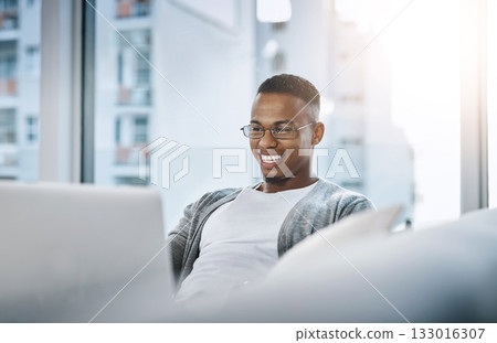 Home, man and laptop working on sofa or elearning, remote study or distance learning and online studying with internet communication. Black student, happy on computer in apartment or living room Home, man and laptop working on sofa or elearning, remote study or distance learning and online studying with internet communication. Black student, happy on computer in apartment or living room 133016307