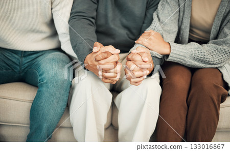 Trust, love and family holding hands on sofa for comforting embrace, prayer and support together at home. Solidarity, empathy and connected parents and adult children for care, compassion and praying 133016867