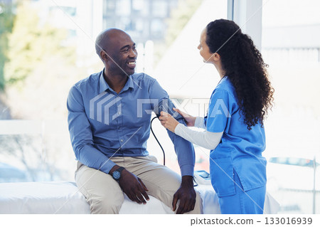 Black man, doctor and blood pressure healthcare in hospital for health insurance consultation. Patient and professional nurse woman talking about hypertension, wellness and advice for healthy life Black man, doctor and blood pressure healthcare in hospital for health insurance consultation. Patient and professional nurse woman talking about hypertension, wellness and advice for healthy life 133016939