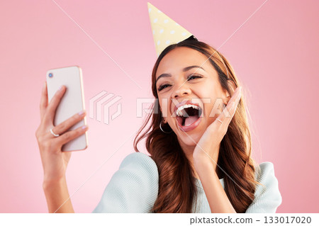 Birthday, selfie and excited with a woman in studio on a pink background for the celebration of an event. Phone, social media and party with an attractive young female celebrating a special occasion Birthday, selfie and excited with a woman in studio on a pink background for the celebration of an event. Phone, social media and party with an attractive young female celebrating a special occasion 133017020