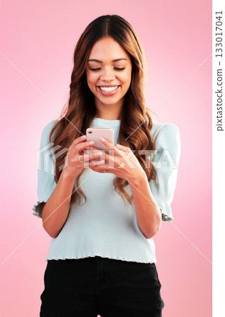 Phone, texting and happy woman in studio online for communication, social media or app on pink background. Internet, smartphone and girl smile with streaming, subscription or website search isolated Phone, texting and happy woman in studio online for communication, social media or app on pink background. Internet, smartphone and girl smile with streaming, subscription or website search isolated 133017041