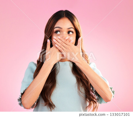 Quiet, surprise and a beautiful woman with a secret isolated on a pink background in a studio. Wow, embarrassed and a girl covering her mouth with a hand for gossip, expression and amazement 133017101