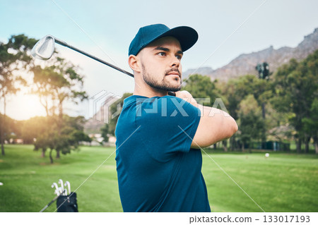 Golf, focus and hobby with a sports man swinging a club on a field or course for recreation and fun. Golfing, grass and stroke training with a male golfer playing a game on a green during summer 133017193