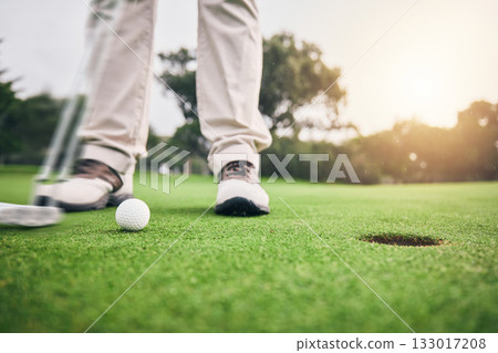 Golf, hole and legs of athlete or player hit ball and professional golfer training and putting on a filed as exercise or workout. Feet, equipment and gentleman or person relax and playing a sport 133017208
