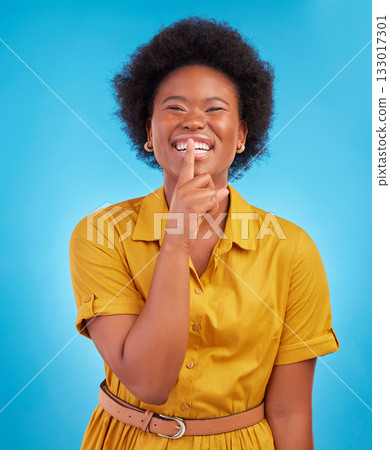 Portrait, smile and secret with a black woman in studio on a blue background standing finger on lips. Gossip, whisper and mystery withan attractive young female making a hand gesture emoji of privacy Portrait, smile and secret with a black woman in studio on a blue background standing finger on lips. Gossip, whisper and mystery withan attractive young female making a hand gesture emoji of privacy 133017301