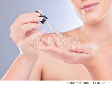 Skincare beauty, hands and woman with serum for glowing skin hydration, anti aging or facial protection. Spa person with liquid product, collagen oil or hyaluronic acid dropper on studio background Skincare beauty, hands and woman with serum for glowing skin hydration, anti aging or facial protection. Spa person with liquid product, collagen oil or hyaluronic acid dropper on studio background 133017308