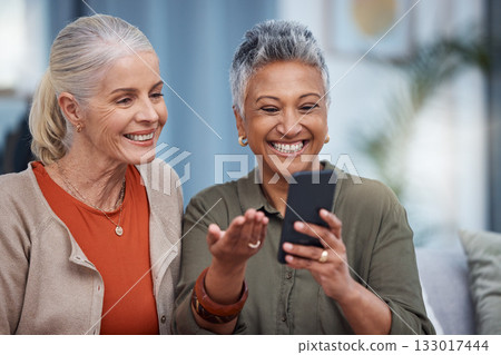 Elderly women smile, phone social media and living room with senior females on web mobile. Video streaming, happiness and conversation at a house with old people together on technology at home Elderly women smile, phone social media and living room with senior females on web mobile. Video streaming, happiness and conversation at a house with old people together on technology at home 133017444