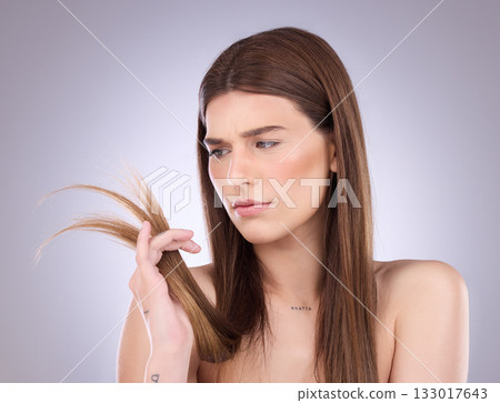 Woman, worry and split ends in studio, background and beauty concern of hair loss, problem and damage. Worried, unhappy and female model check tips of haircare, hairstyle and treatment of dry texture 133017643